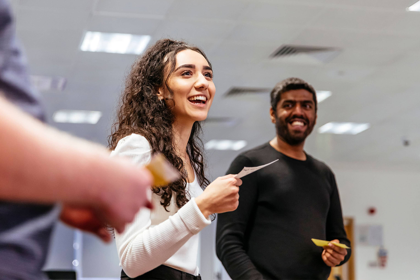 Male and female colleagues laugh at work