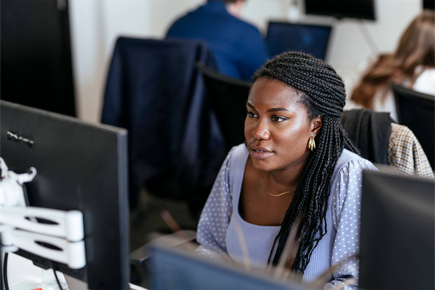 Young woman with braids working on a big screen