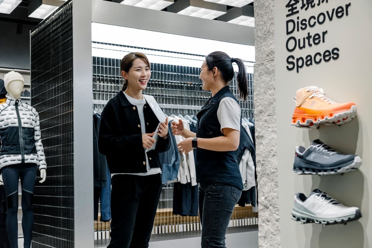 Two women chatting in a shoe display unit