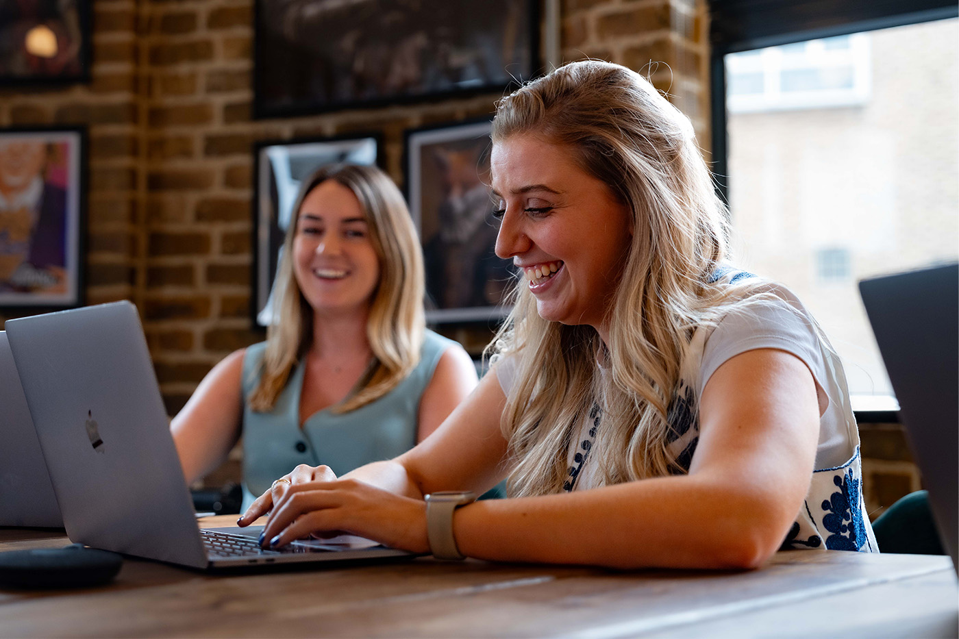 Two female colleagues smiling during a meeting
