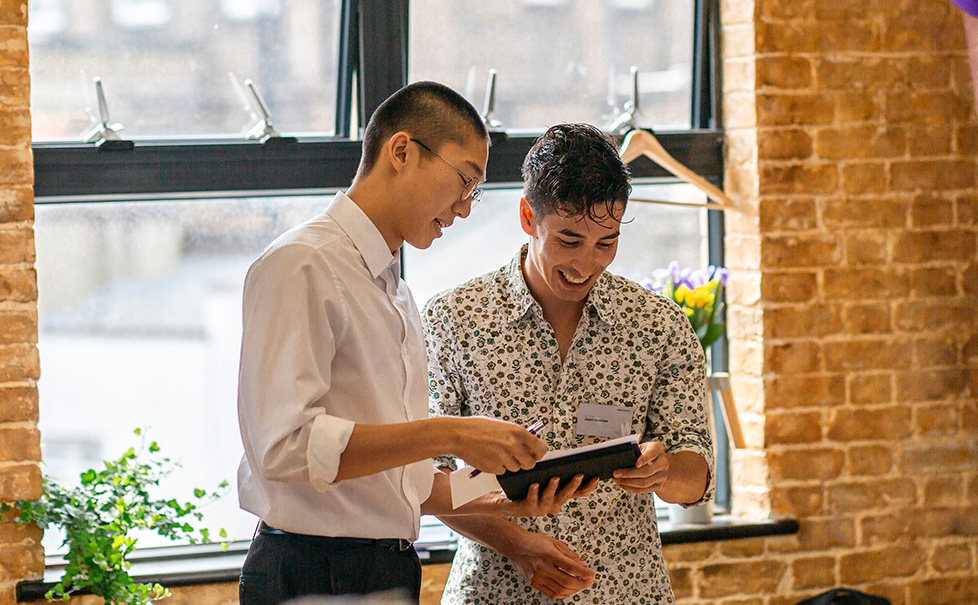 Two male students working on an iPad