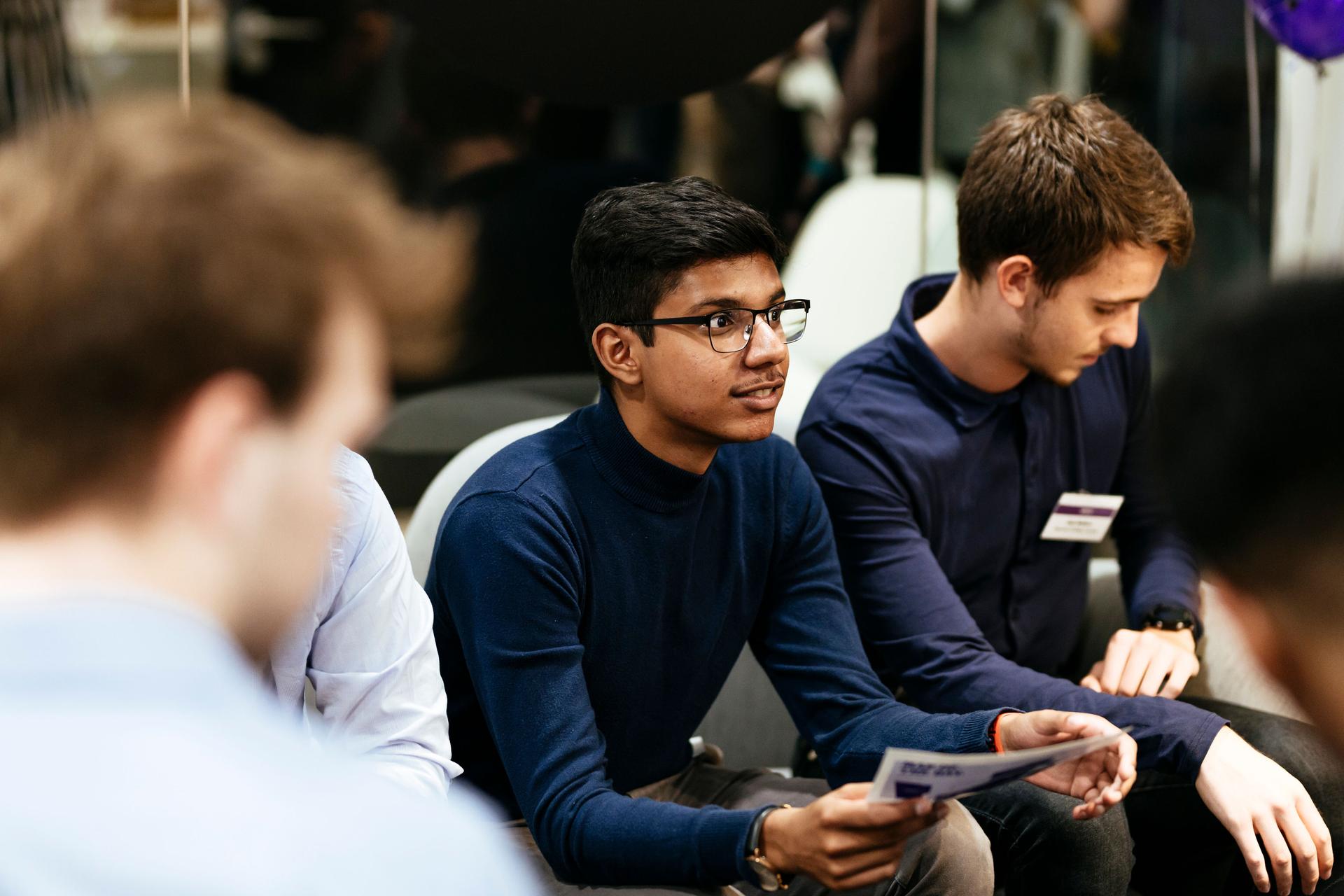 A young male student listening intently and engaging in conversation