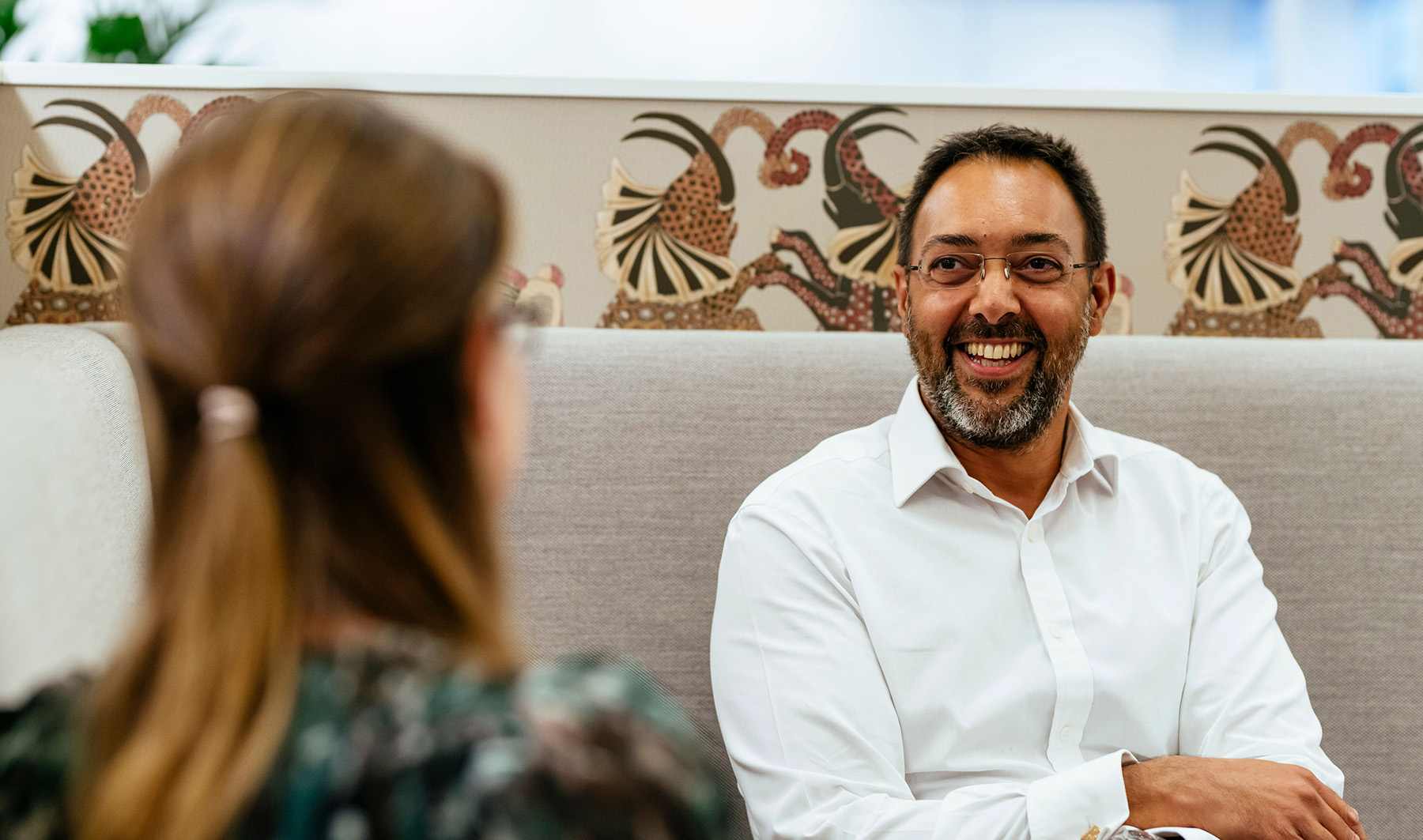 Male and female colleagues laugh at work