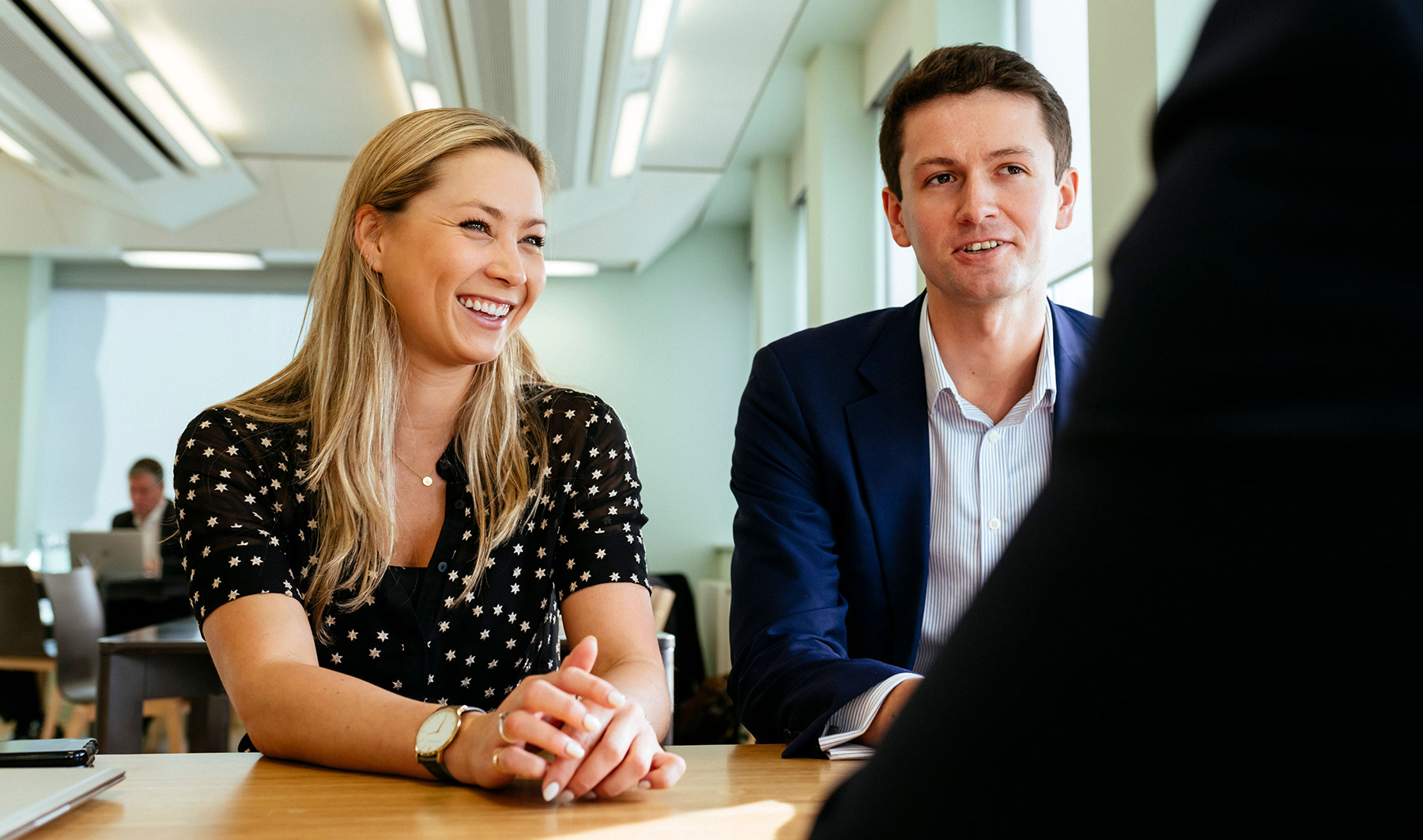 Team meeting between mixed colleagues laughing together