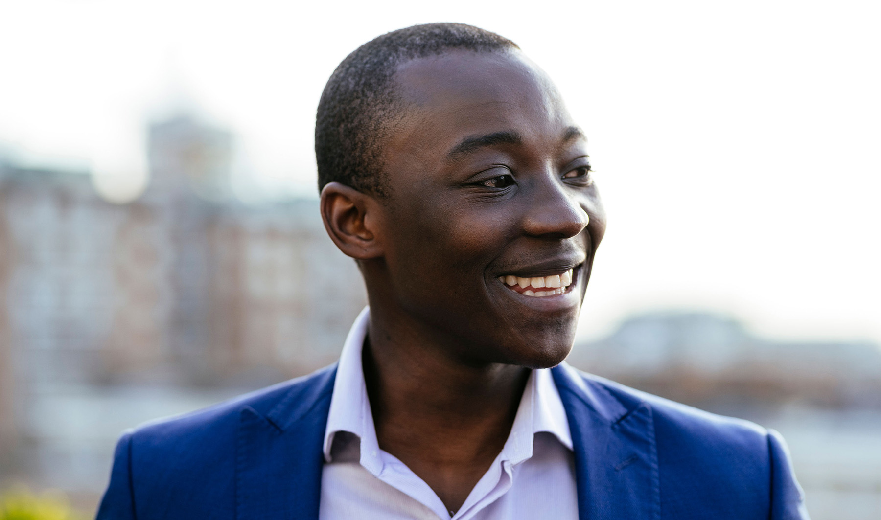 Smiley young man wearing a suit in a rooftop garden