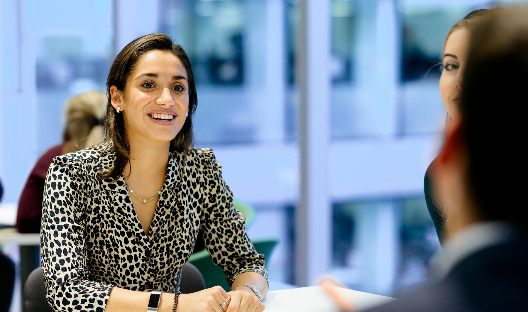 Close up of a young woman in a patterned shirt during a business meeting