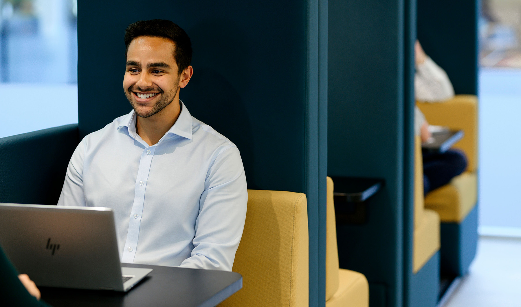 Young man in smart shirt smiling during a meeting