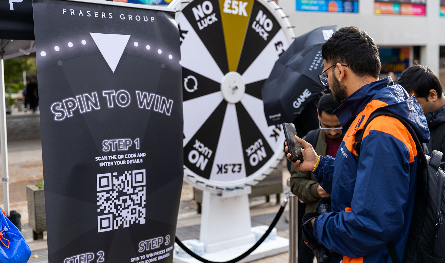 Photo of male student scanning a QR code on campus