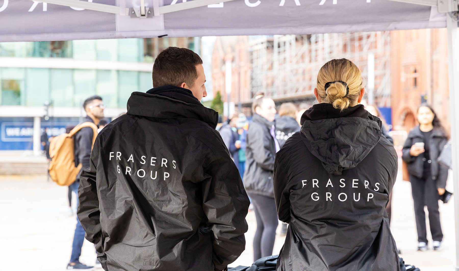 The back of 2 Frasers Group promoters wearing branded jackets
