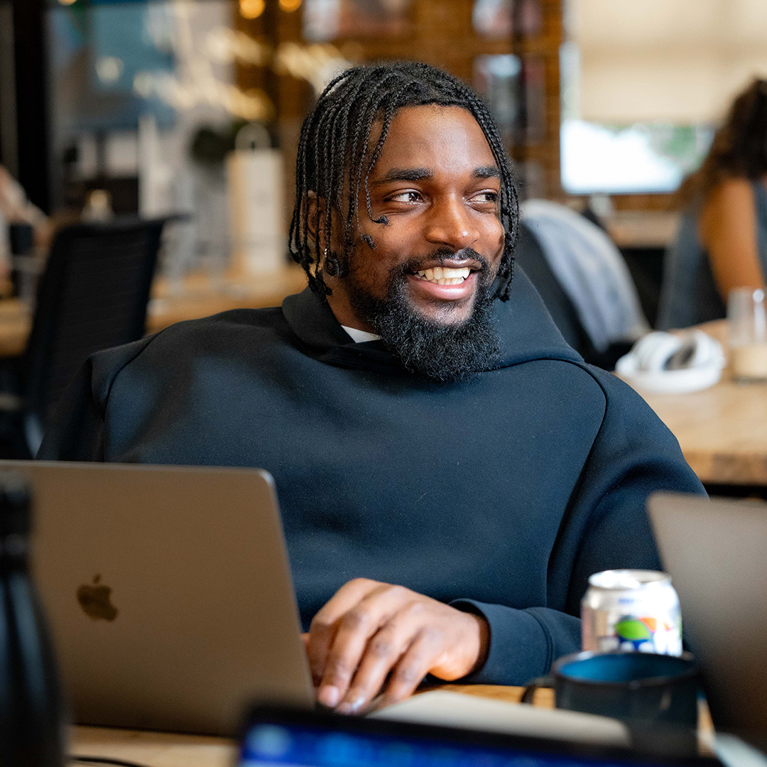 Image of young man smiling while using laptop