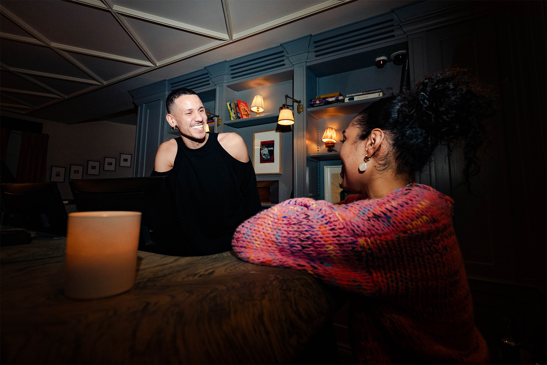 Flash photograph of two Soho House colleagues smiling at work