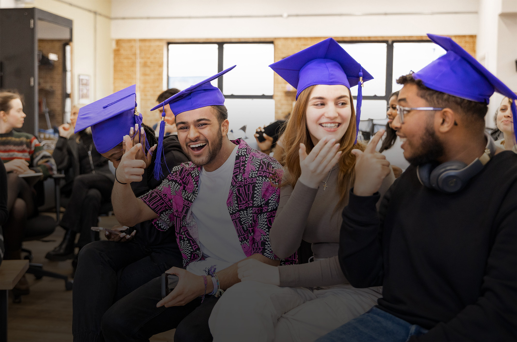 Image of three students wearing purple graduation caps