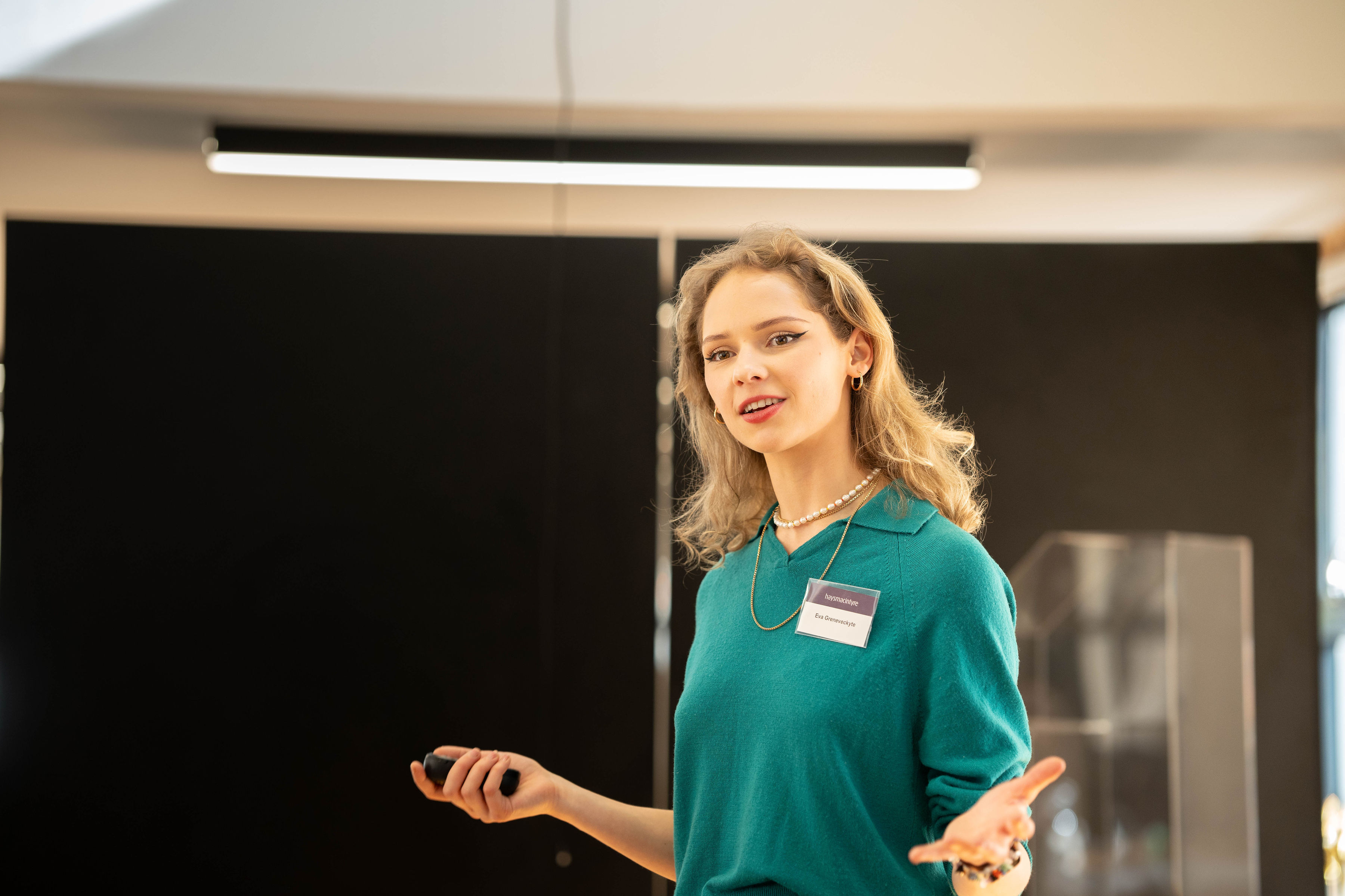 Photo of female with blonde hair presenting in a green jumper