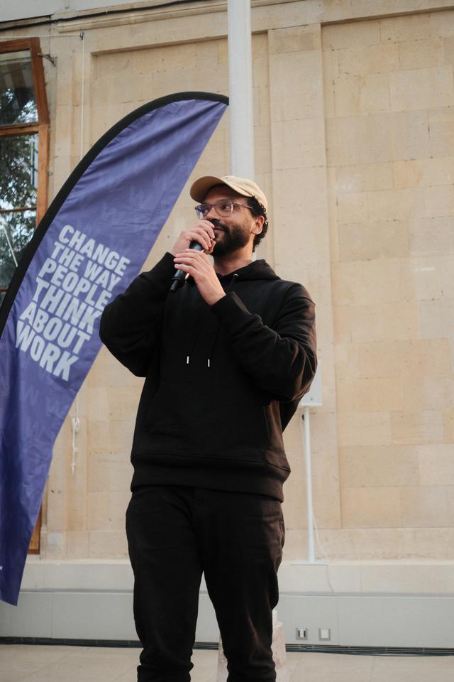 Man with beard speaking into a microphone