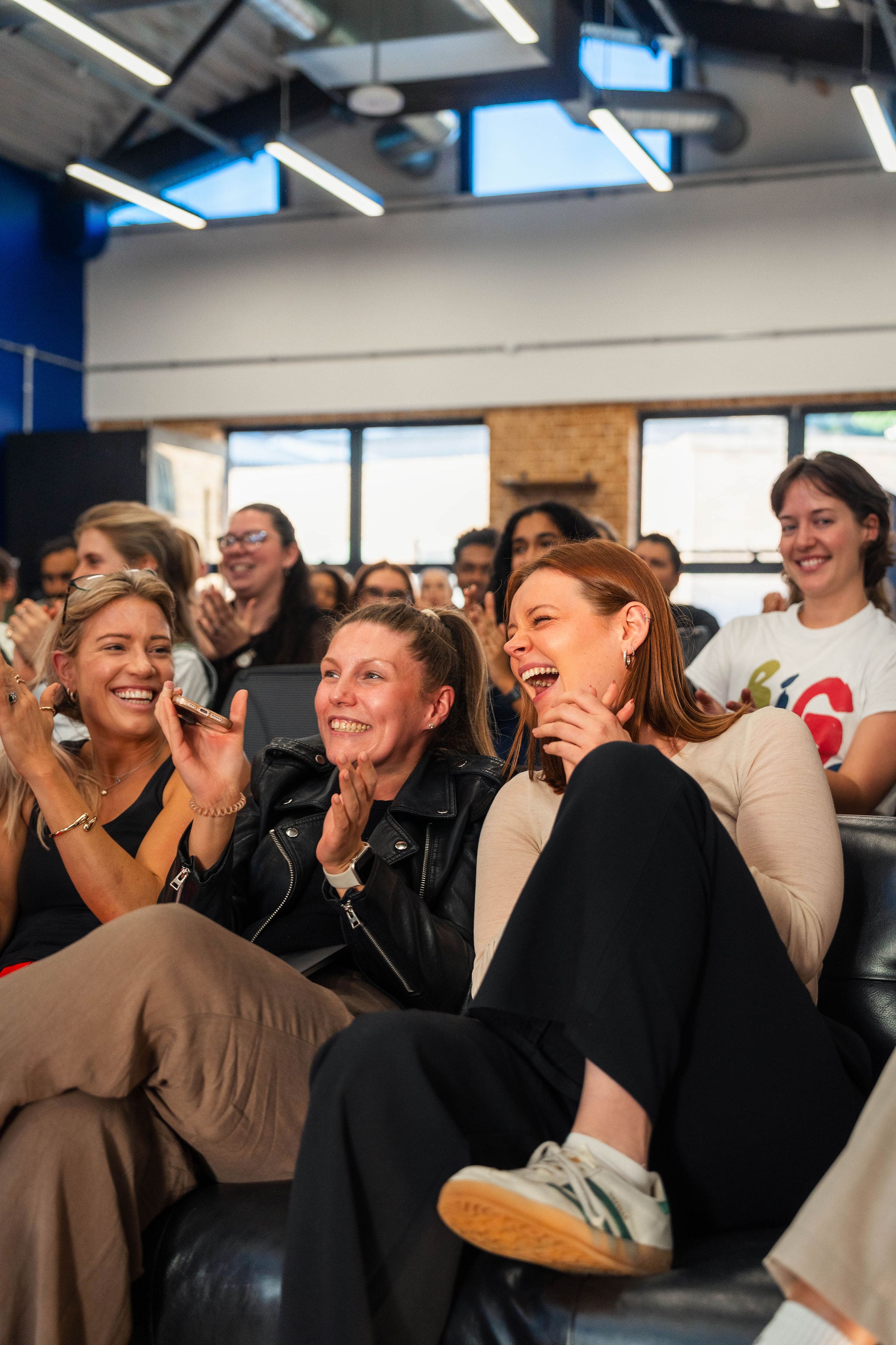 Female friends laughing in a crowd at work