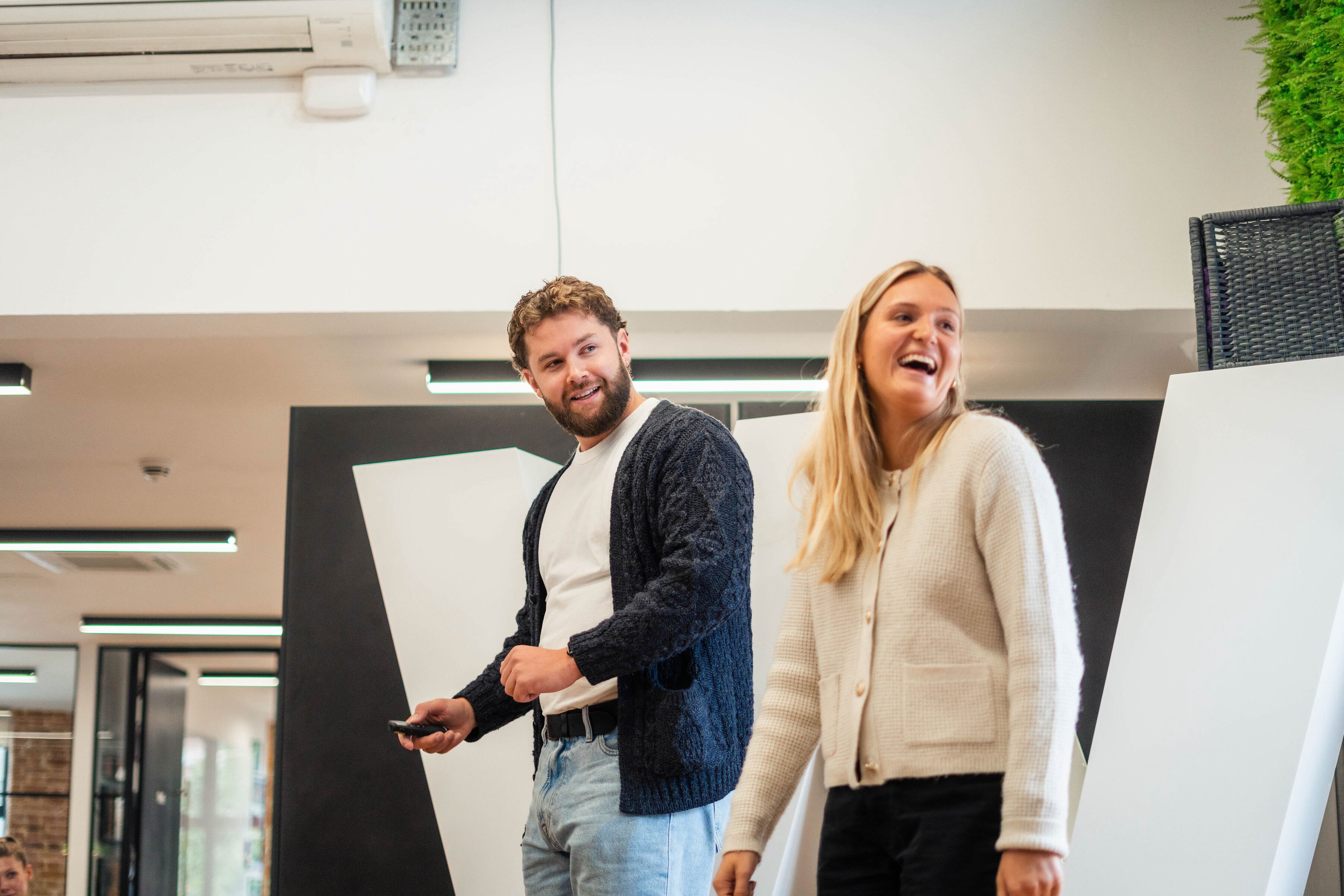 Photo of Wiser talent team presenting on stage, male is where a white tshirt and blonde female in a cream cardigan