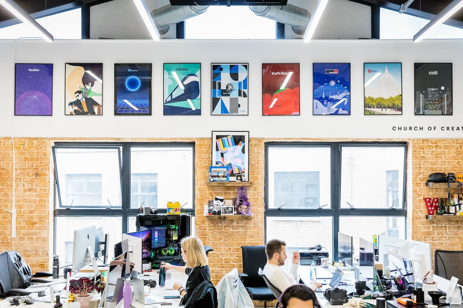 Photo of a wall within Wiser with people working at their desks below.