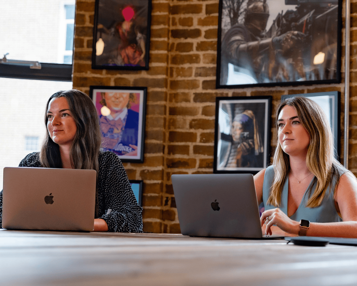 photo of two females with brown hir watching a presentation