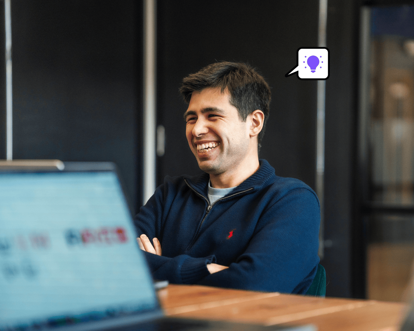 Photo of man with dark hair sat at desk