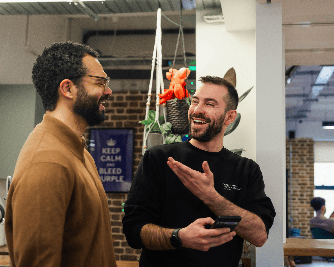 Photo of two males laughing to each other in the office