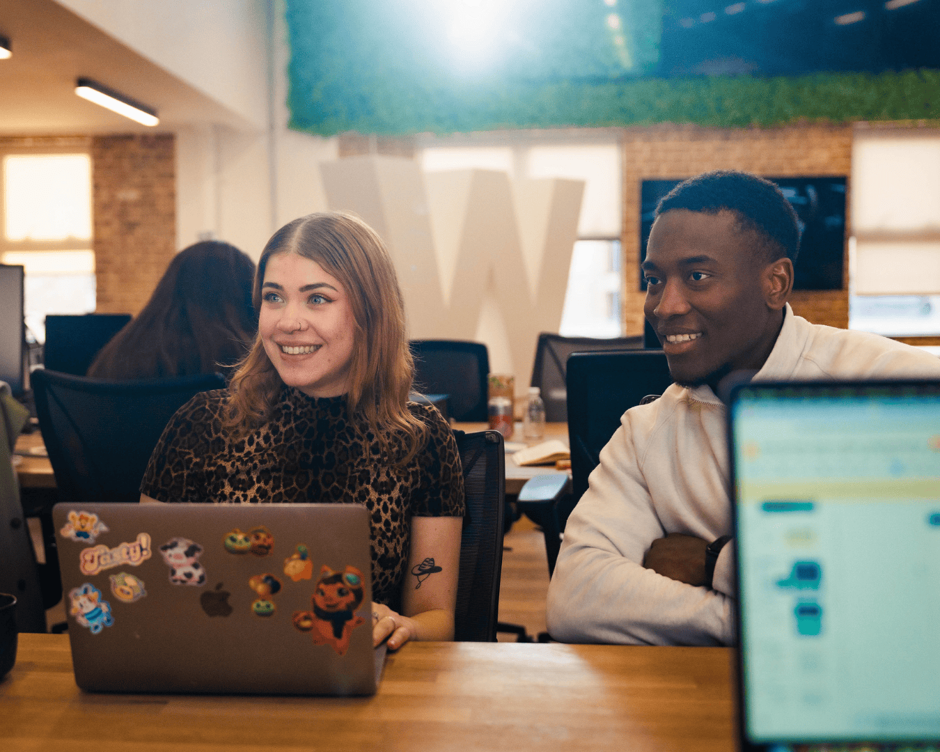 Photo of male and female talking at a desk