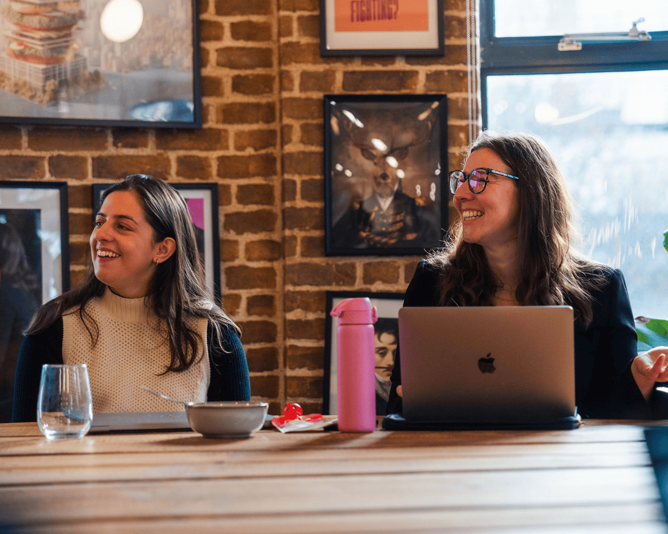Photo in a team meeting, two females looking at a screen