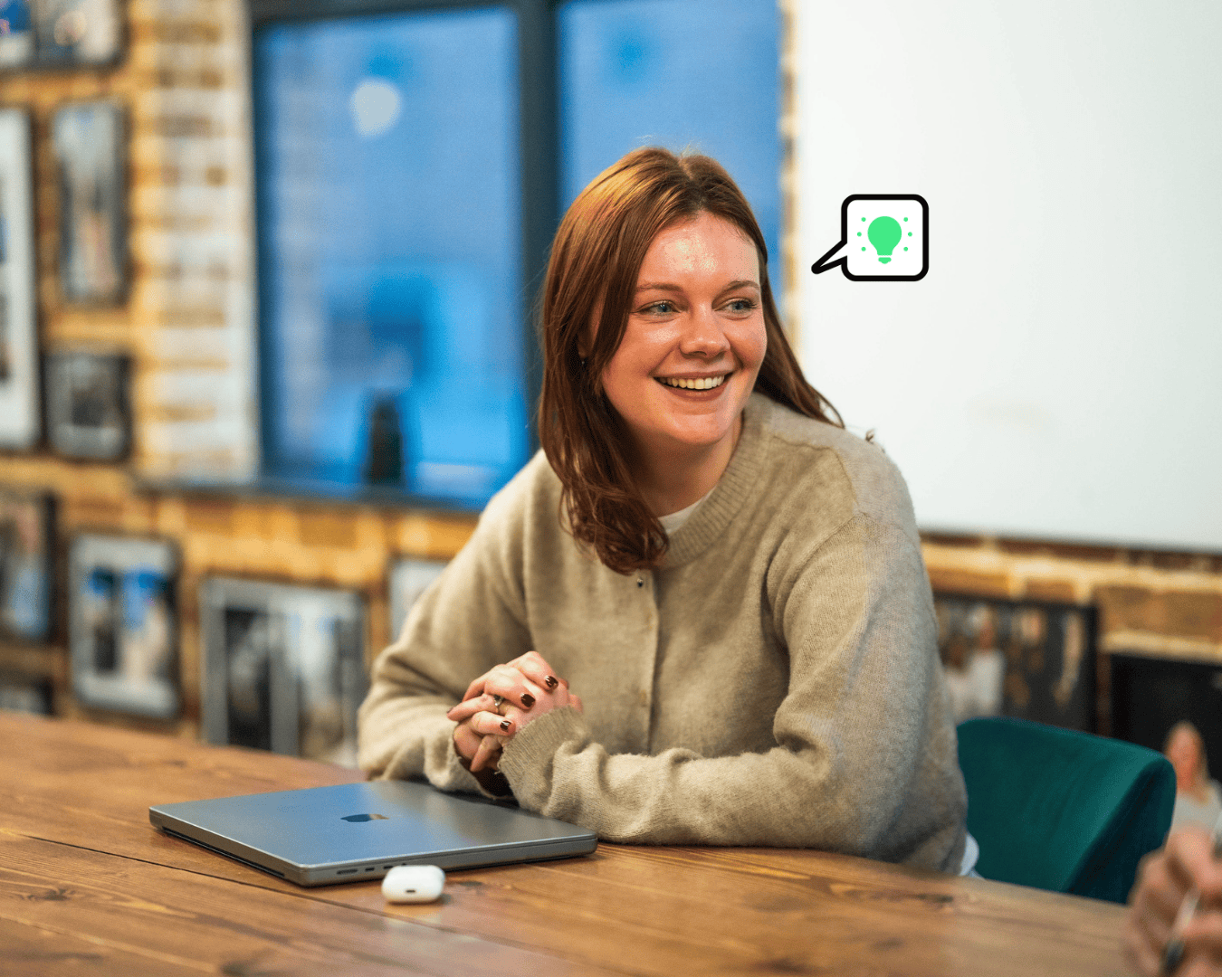 Photo of female at a table in a meeting room smiling