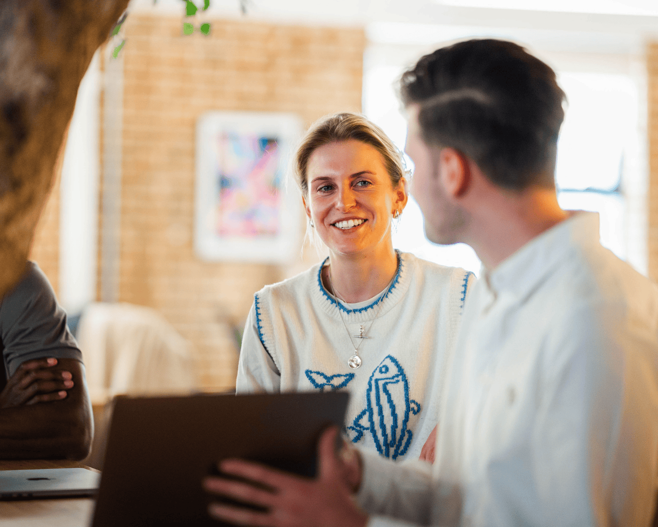 Smiling employee in conversation with a colleague, showcasing connection and authentic workplace advocacy