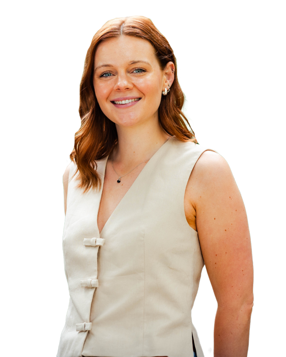 White woman with shoulder-length auburn hair smiles outdoors, wearing a sleeveless cream waistcoat — embodying clarity and confidence in employer brand storytelling and inclusive recruitment strategies.