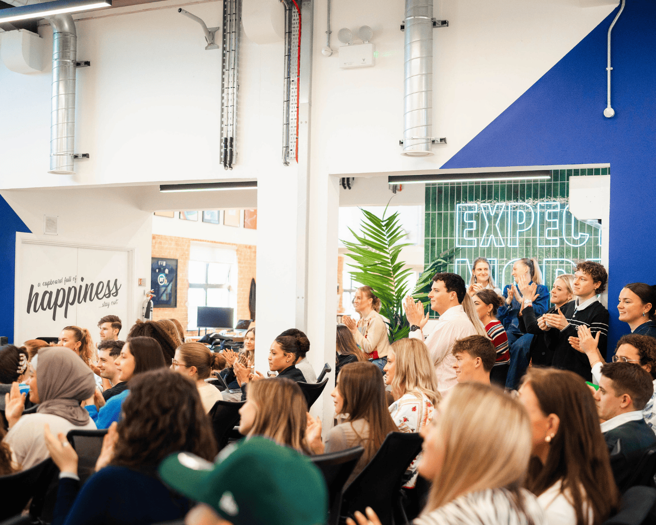 Photo in an office with a crowd of people clapping