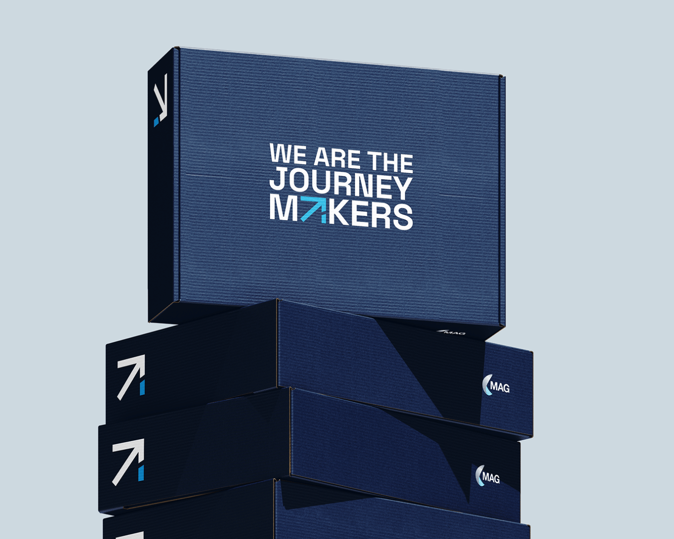 A stack of navy blue boxes with the top one displaying the bold text, "We Are The Journey Makers", against a light gray background
