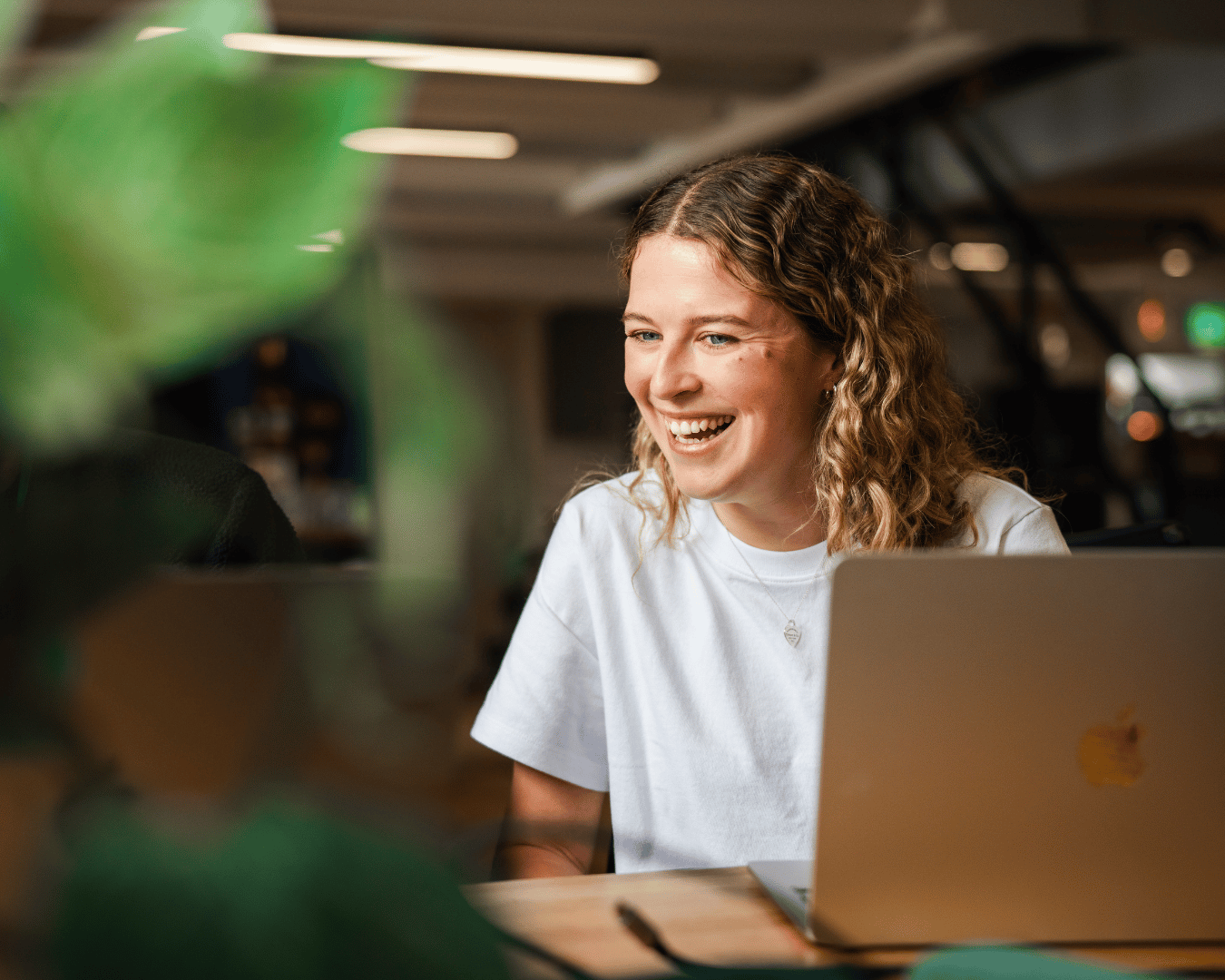 Photo of a girl with blonde curly hair with a laptop infront of her
