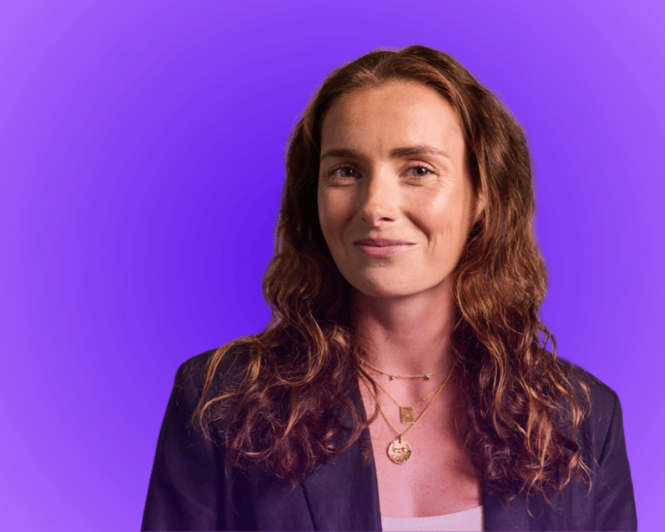 Headshot of lady with brown hair and a blazer with a purple gradient background