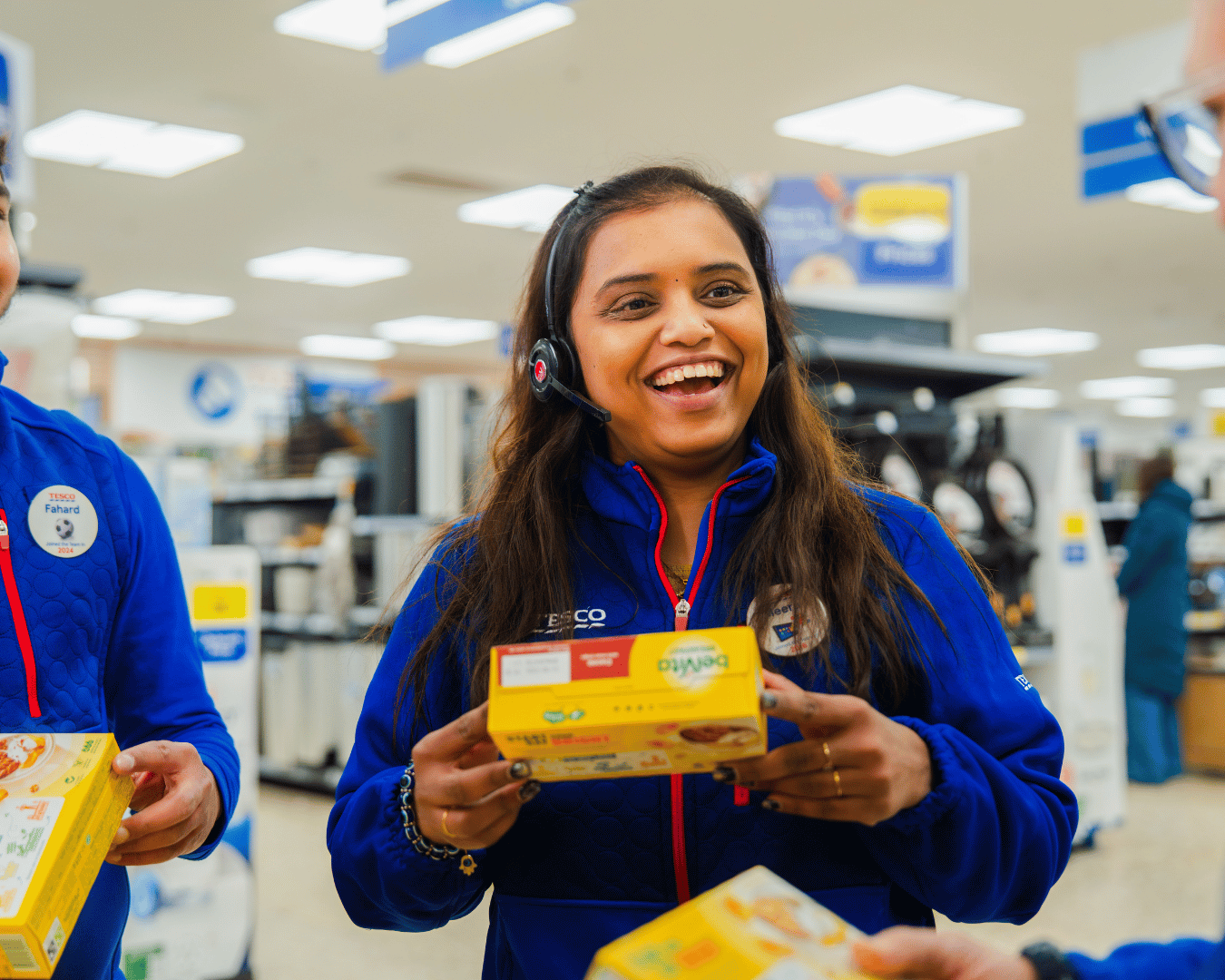 Photo of a female on a supermarket floor smiling and holding a box a belvita