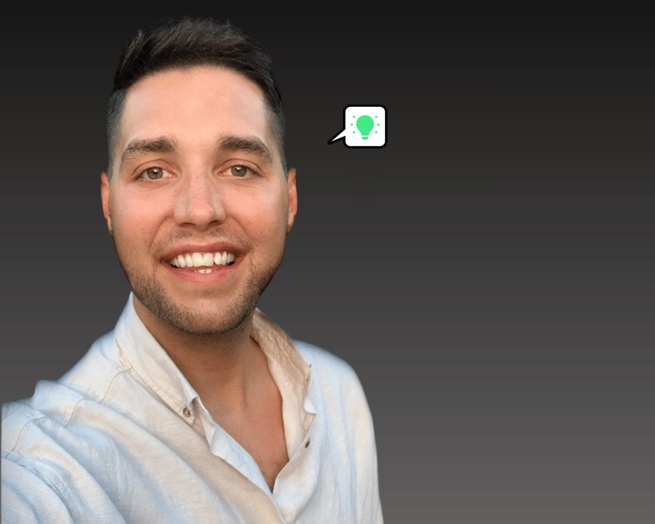 photo of a male smiling with brown hair and a white shirt with a grey gradient in the background