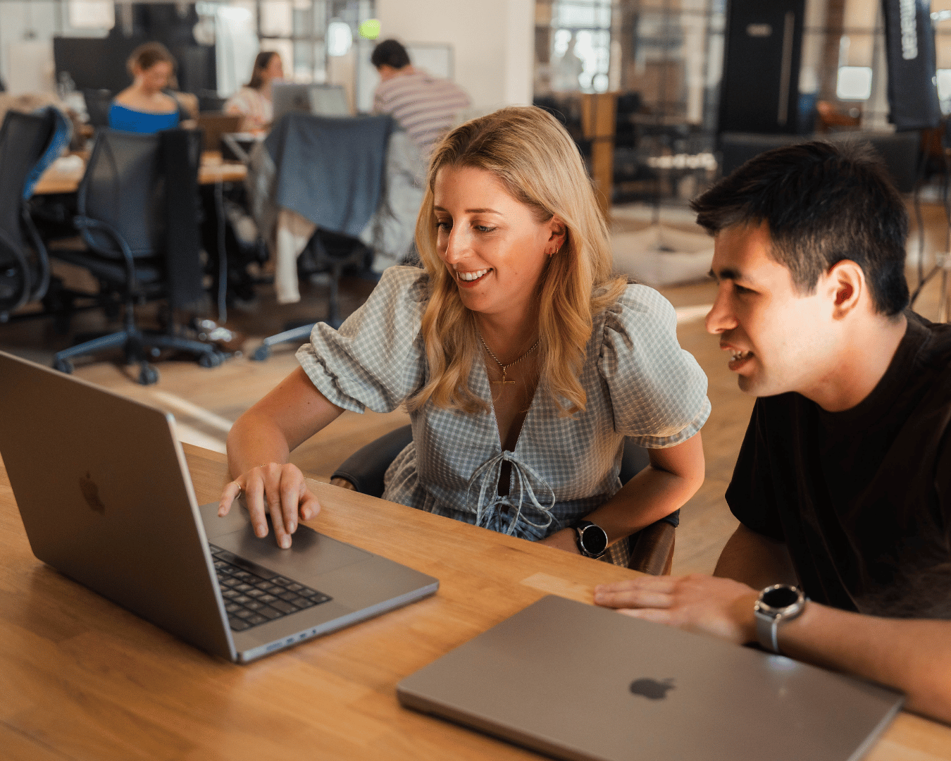 A photo of two people looking at a laptop and smiling