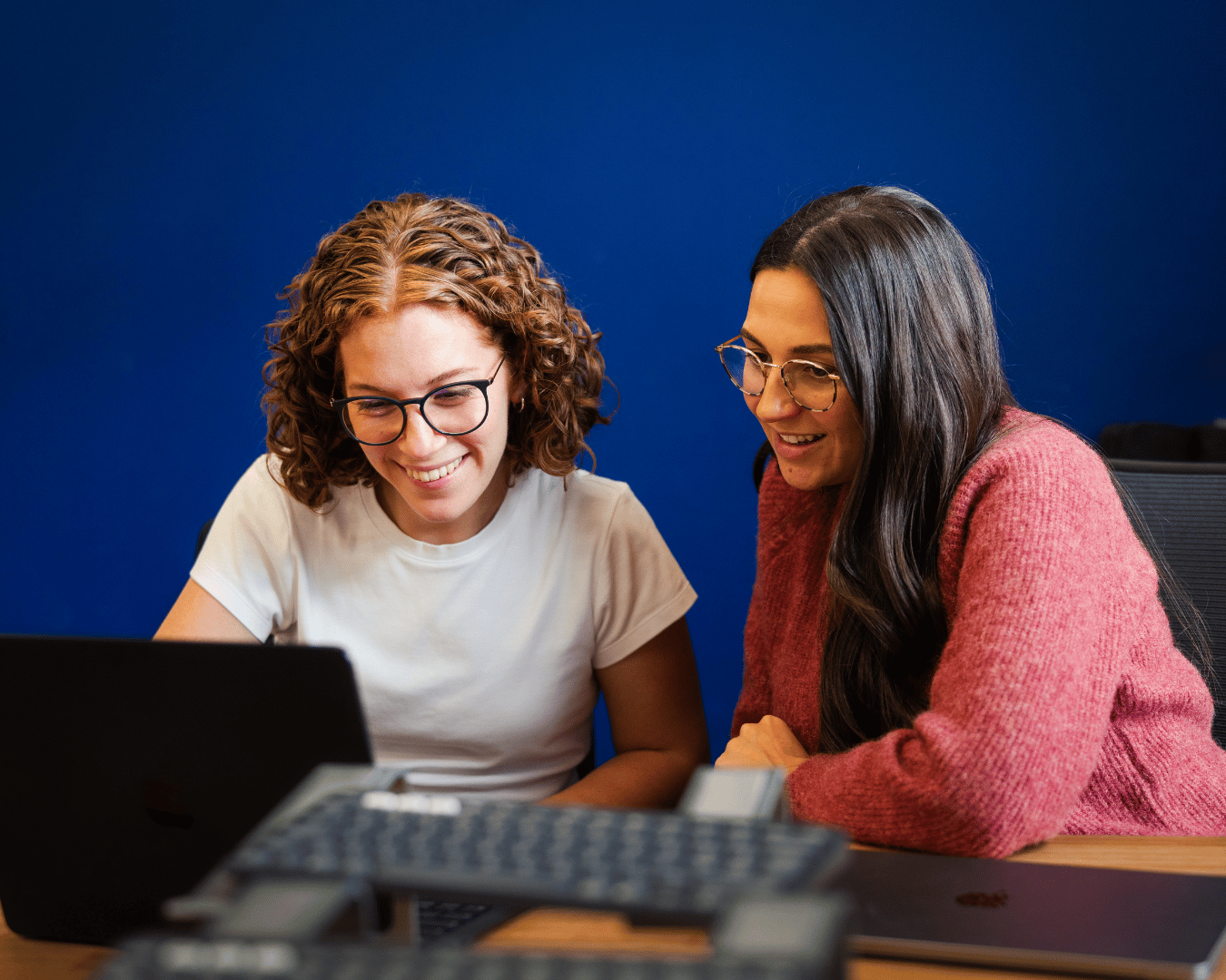 photo of two females looking at a laptop smiling
