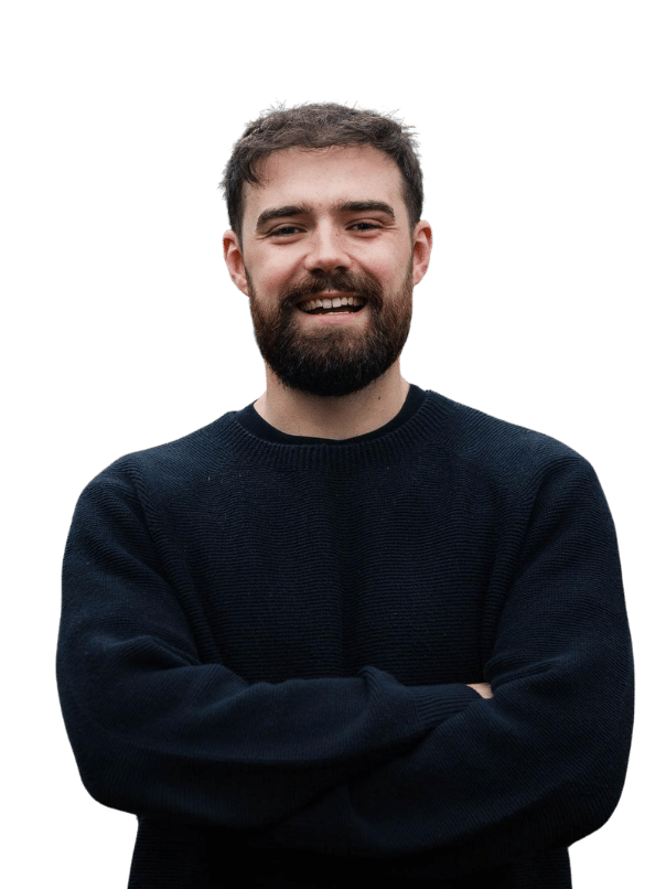 Photo of a male with brown hair and a beard and a black jumper smiling