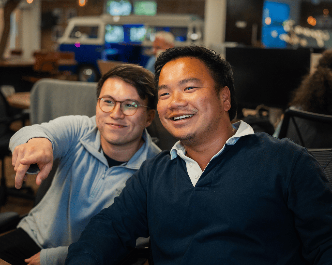 photo of two men looking at a screen and smiling