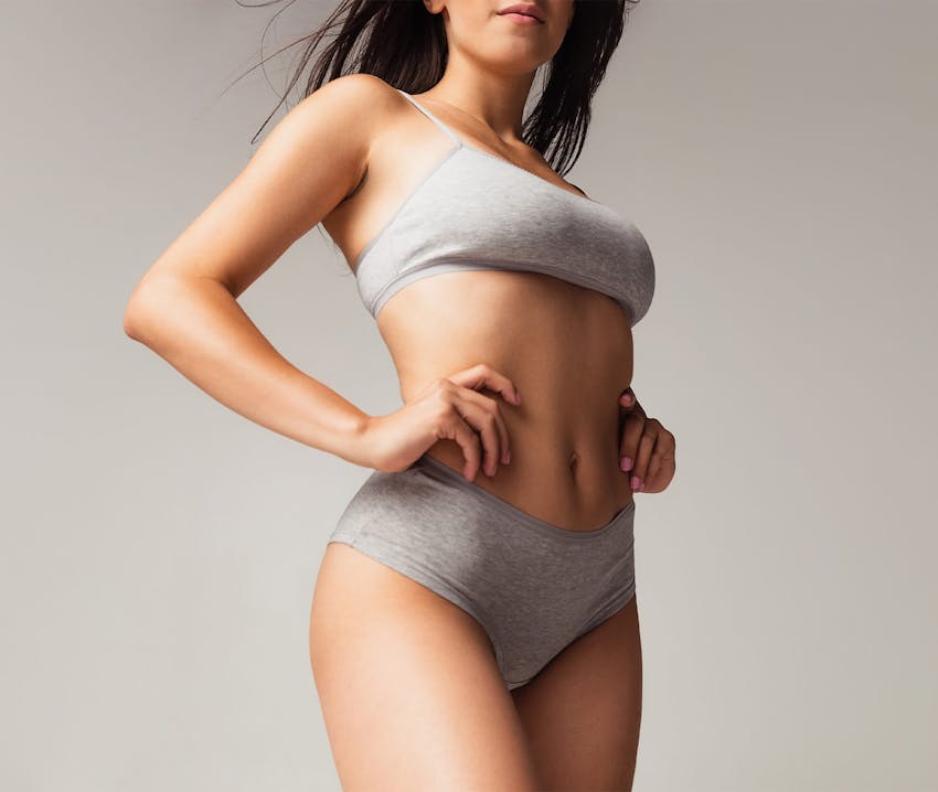 woman in gray underwear with hands on her waist