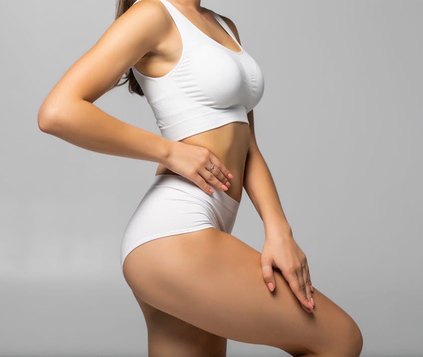 model posing like flamingo with hand on her hip in white underwear