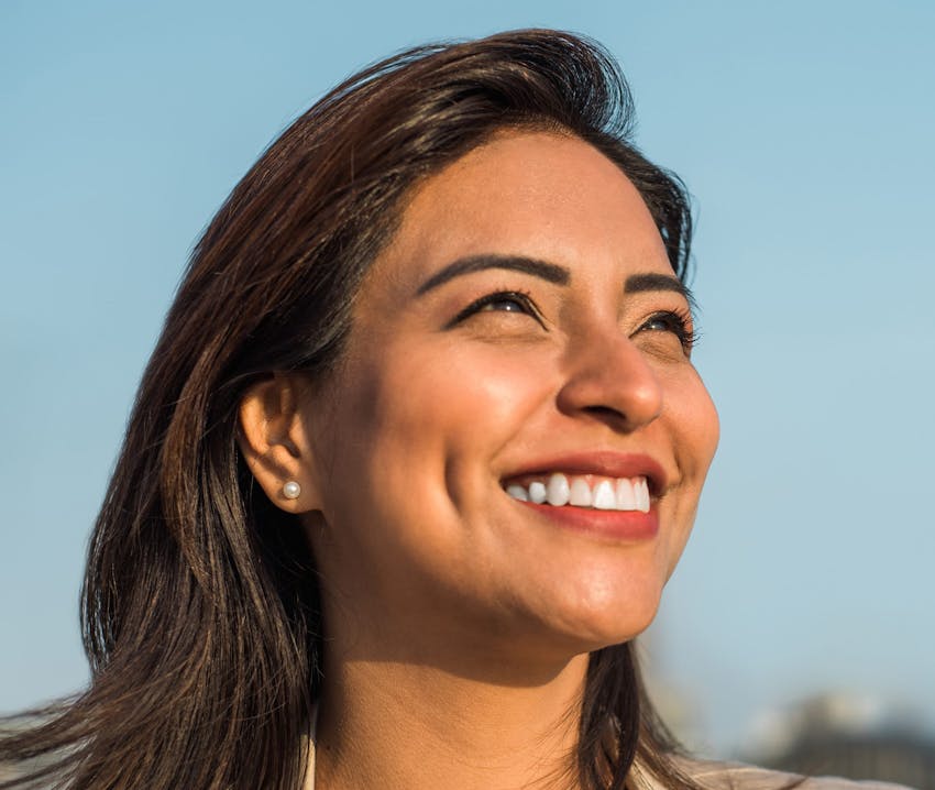 woman smiling with the sun hitting her skin