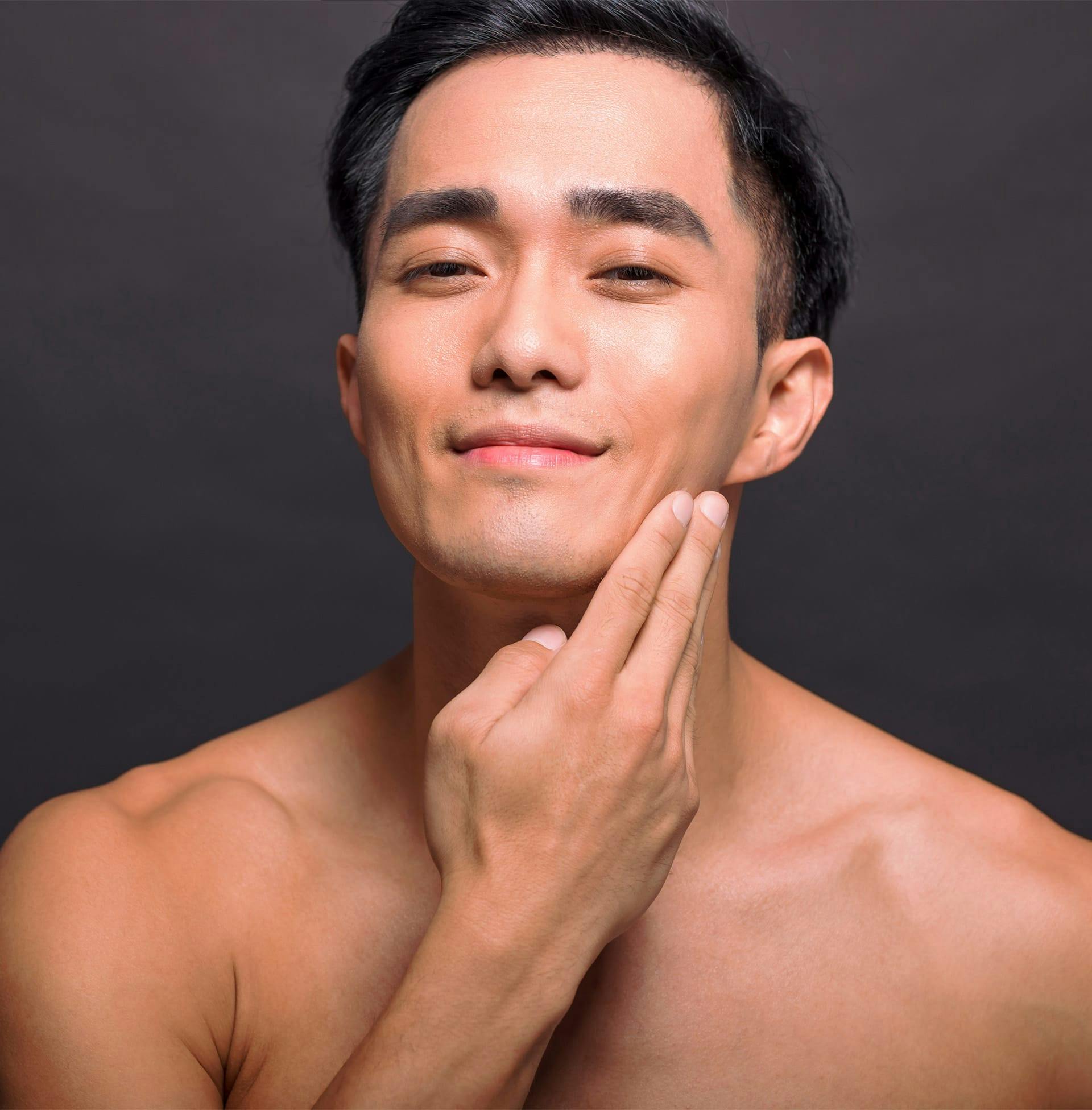 man rubbing hand on his cheek