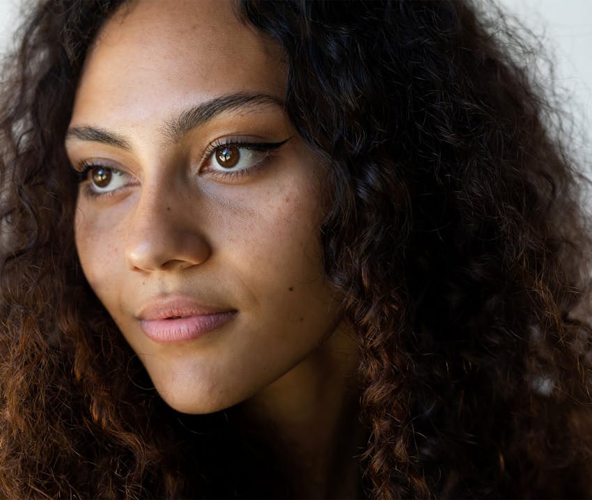 close up of woman with curly hair looking off in the distance