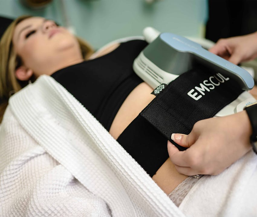 woman laying abut to start emsculpt on her stomach