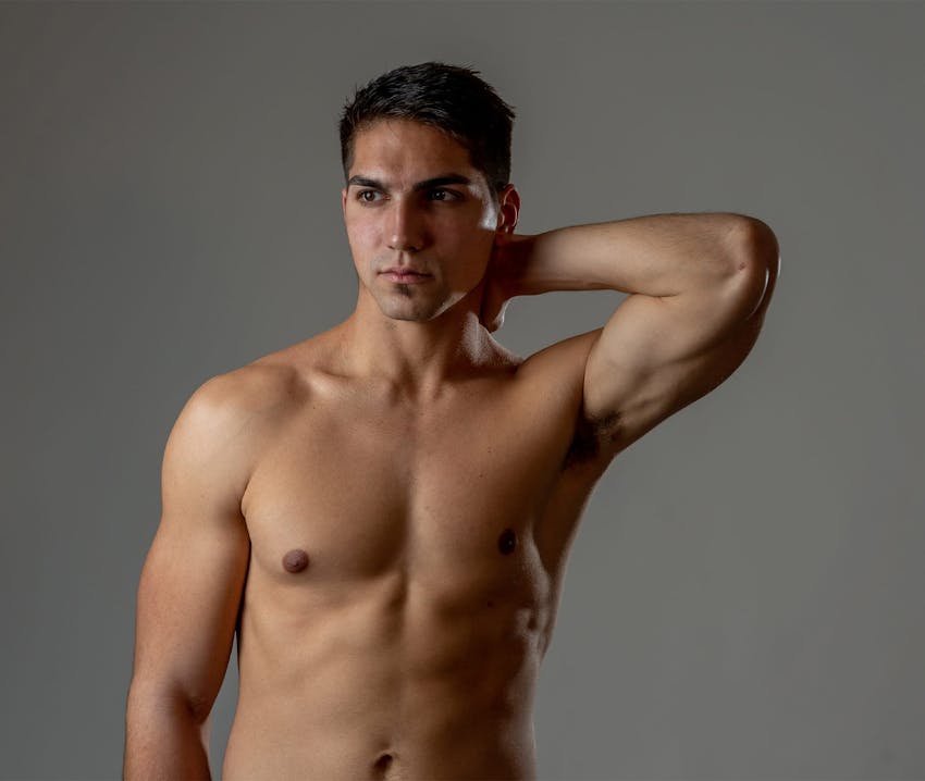 man with hand behind neck with gray background