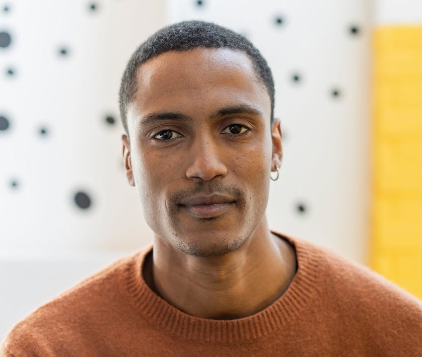 man in orange sweater looking at camera