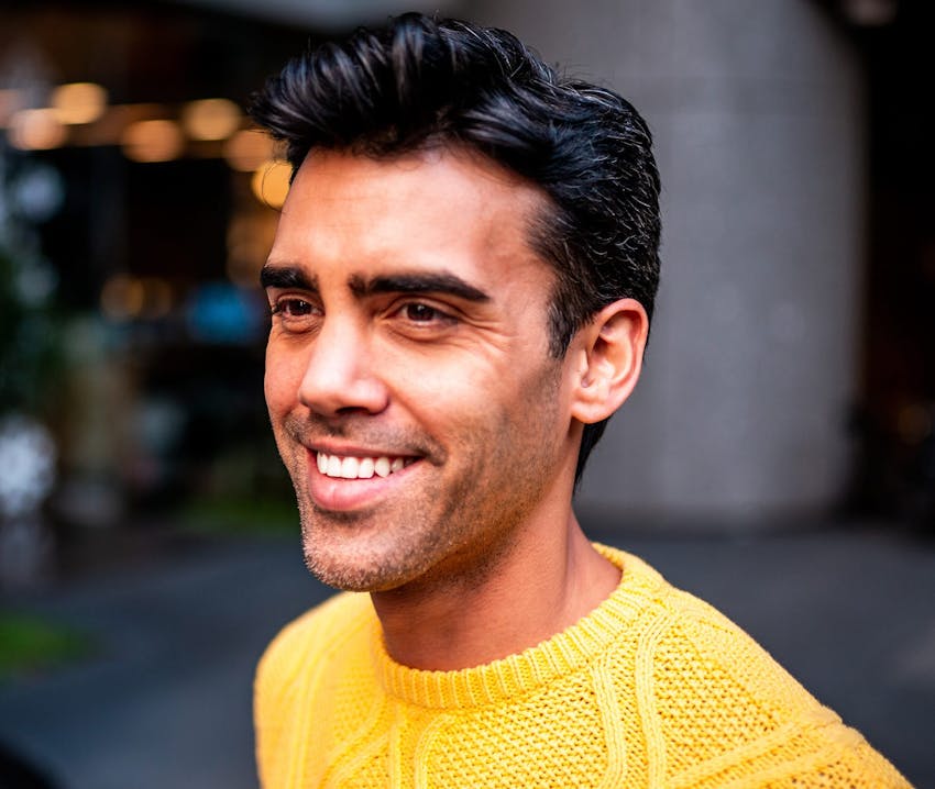 man in bright yellow sweater smiling