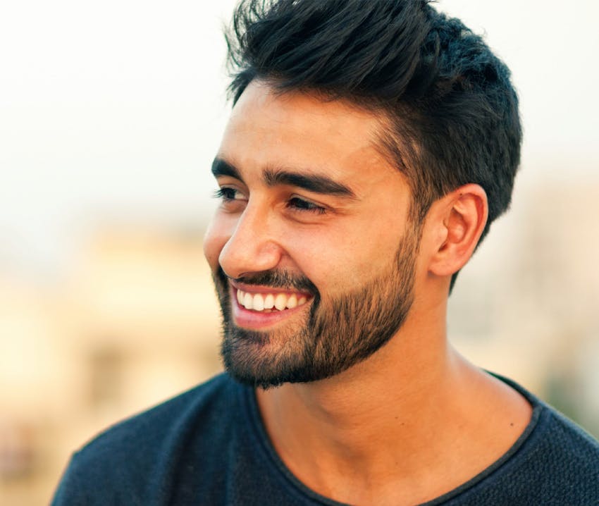 man smiling looking to the left in navy shirt