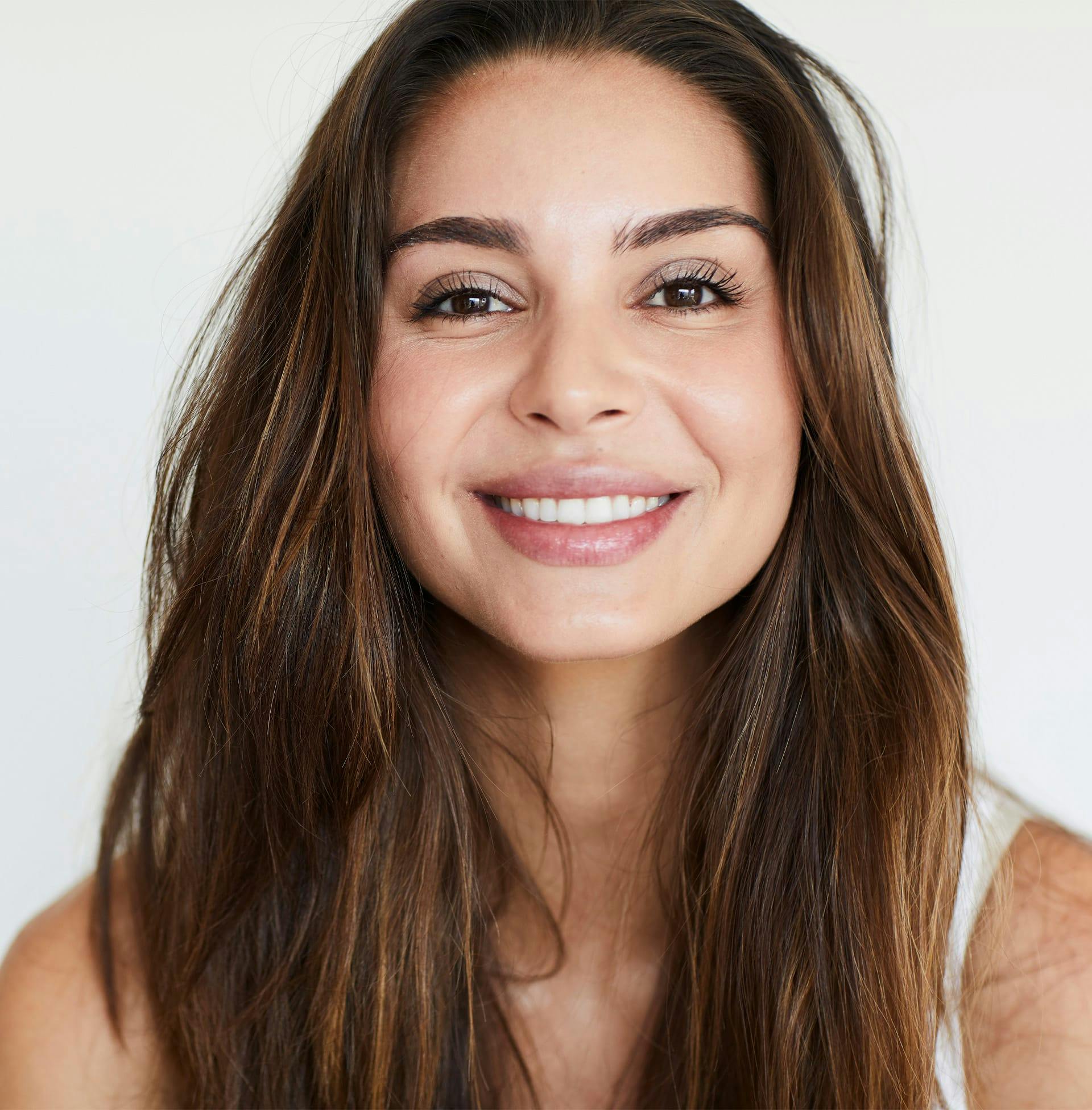 woman with long brown hair smiling at camera